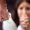 Clenched fist of a man with a woman in the background scared