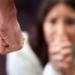 Clenched fist of a man with a woman in the background scared